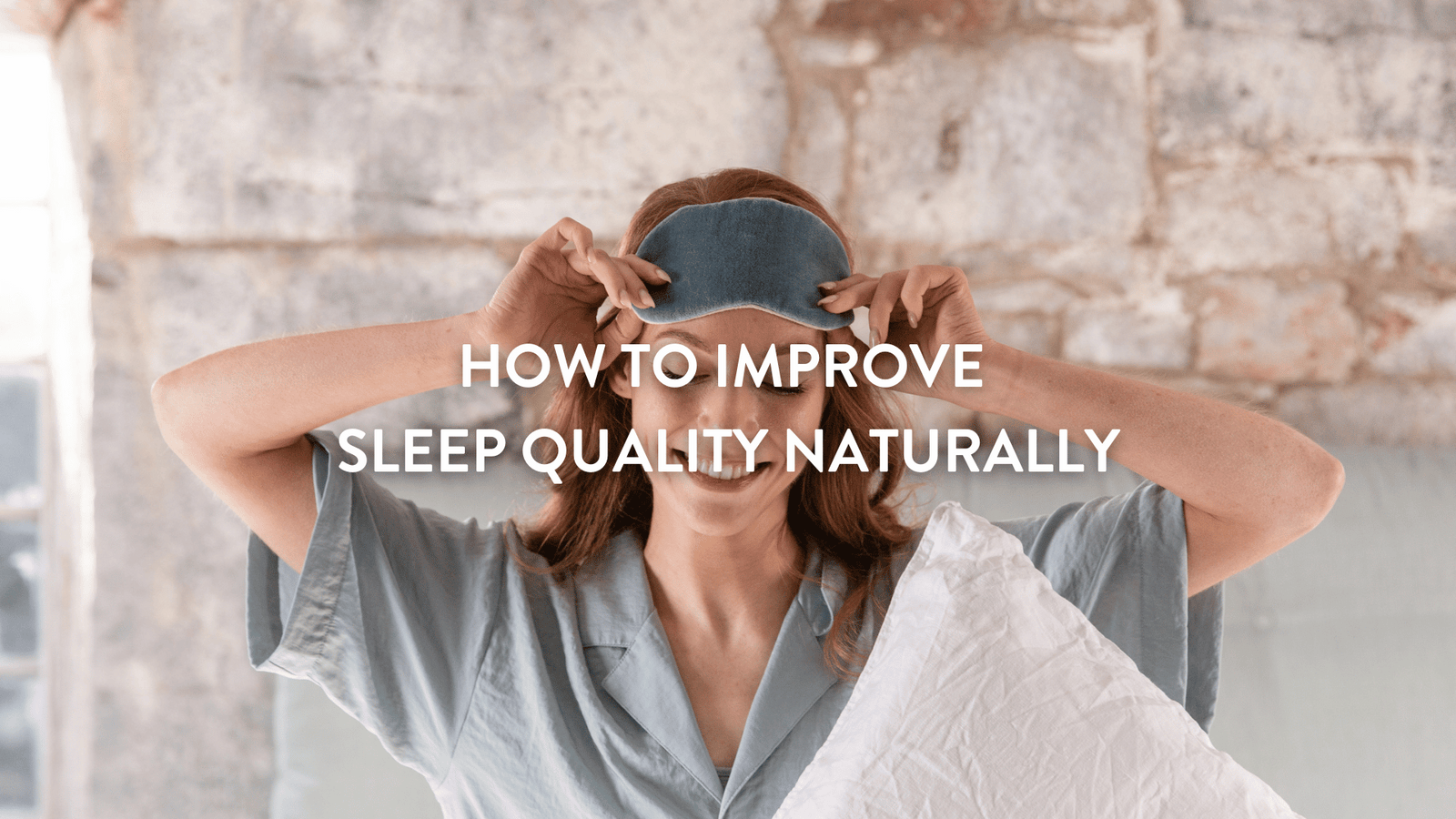 Person sitting up in bed adjusting an eye mask