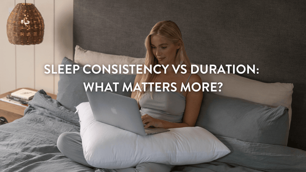 person sitting up in bed working on a laptop