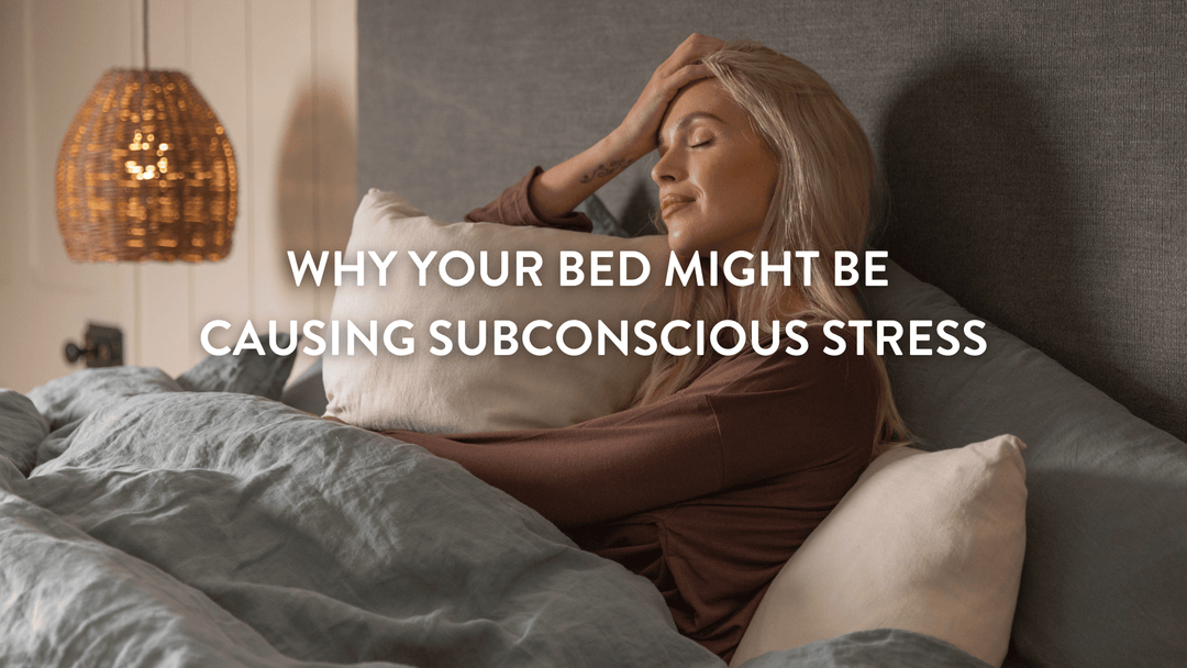 Person sitting up in bed stressed by not being able to sleep holding their head with their eyes shut