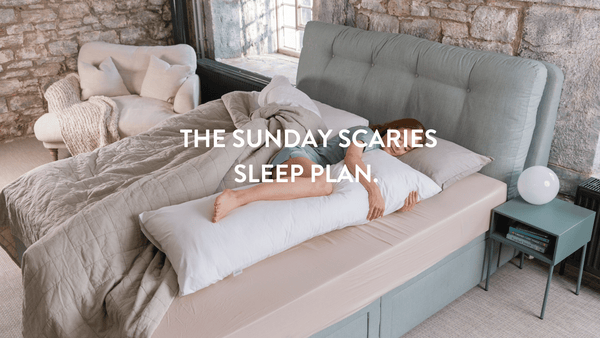 person sleeping in bed surrounded by Putnams comfort pillows 